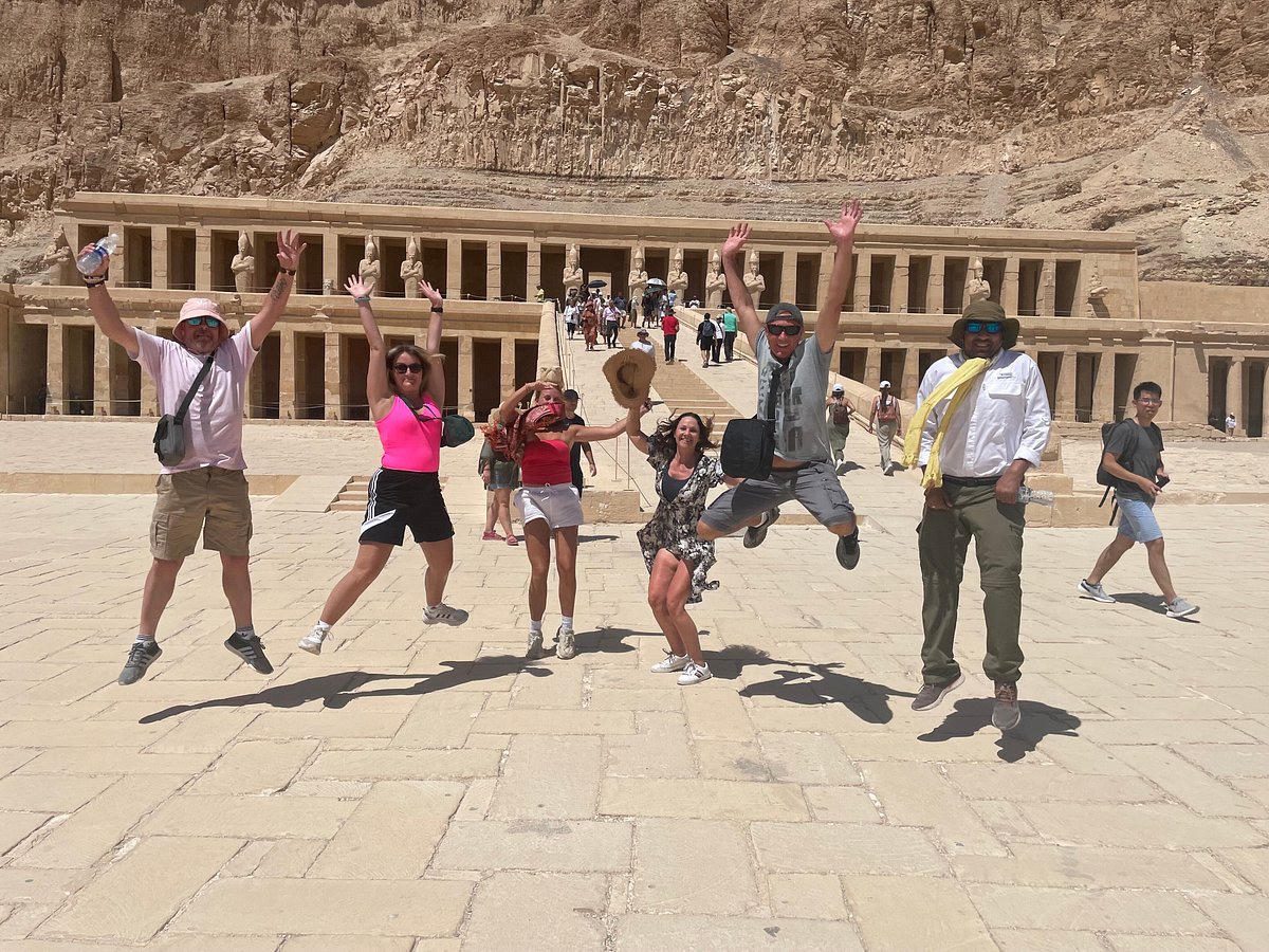 Happy travelers jumping in front of the Temple of Hatshepsut in Luxor